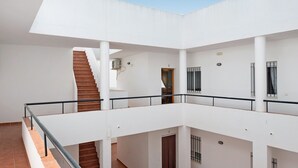 A multi-level interior with a staircase, railings, and a tiled floor.