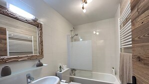 Uma casa de banho moderna com uma grande pia, sanita e banheira.