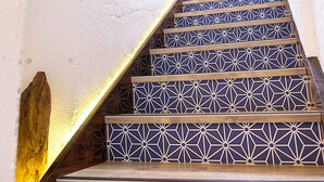 Eine Treppe mit geometrischen Fliesenmustern und Holzhandläufen.