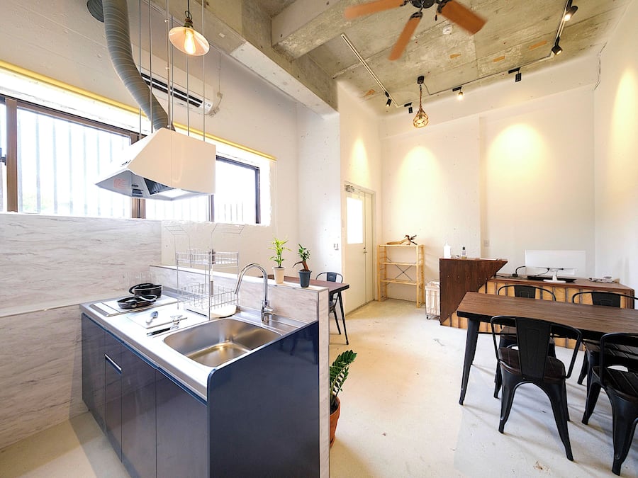 A modern kitchen with a central island, built-in appliances, and a dining area with a wooden table and chairs.