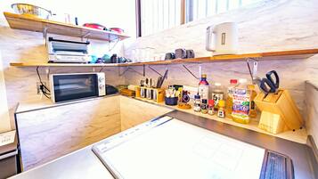 A kitchen with a microwave, toaster, and various kitchen utensils.