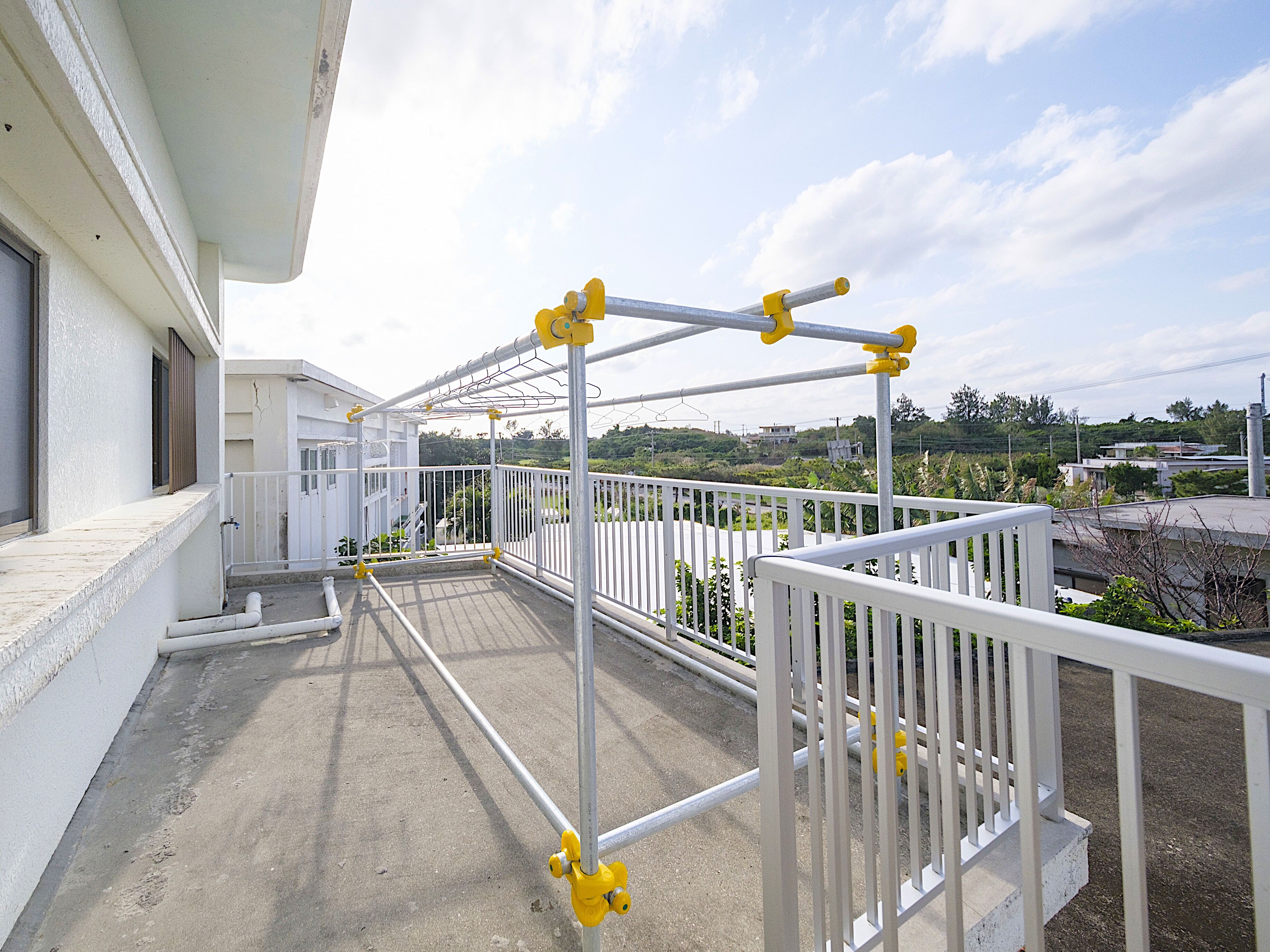 A balcony with a metal railing and a view of the surrounding area.