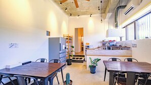 Eine moderne Küche mit Holztisch, Stühlen, Deckenventilator und Kühlschrank.