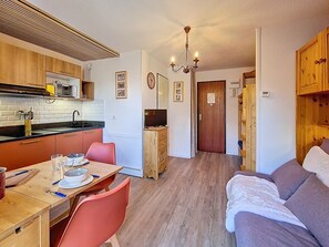 A compact living space with a kitchenette, dining area, and a seating area.