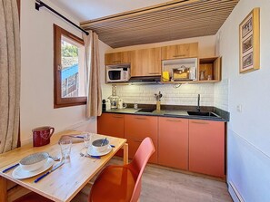 A compact kitchen with a microwave, toaster, and sink.