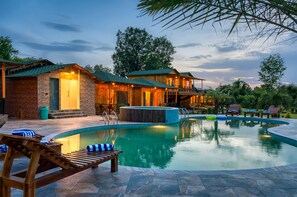 A poolside area with wooden lounge chairs, a hot tub, and a pool. - Pumpkin Hotels Corbett, Tusk N Wood (Ramnagar)