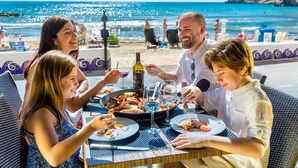 A group of people dining at an outdoor table with a view of the beach and ocean. - A839 - A spacious apartment with garage, air conditioning and pool (Villajoyosa)