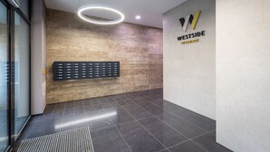 A modern interior with a reception desk, a wall-mounted information board, and a logo for 'Westside Residence'. - Venus Apartments - Westside Residence (Budapest)