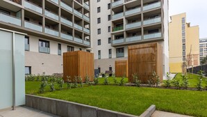 A modern apartment building with multiple balconies, a well-maintained lawn, and a concrete pathway. - Venus Apartments - Westside Residence (Budapest)