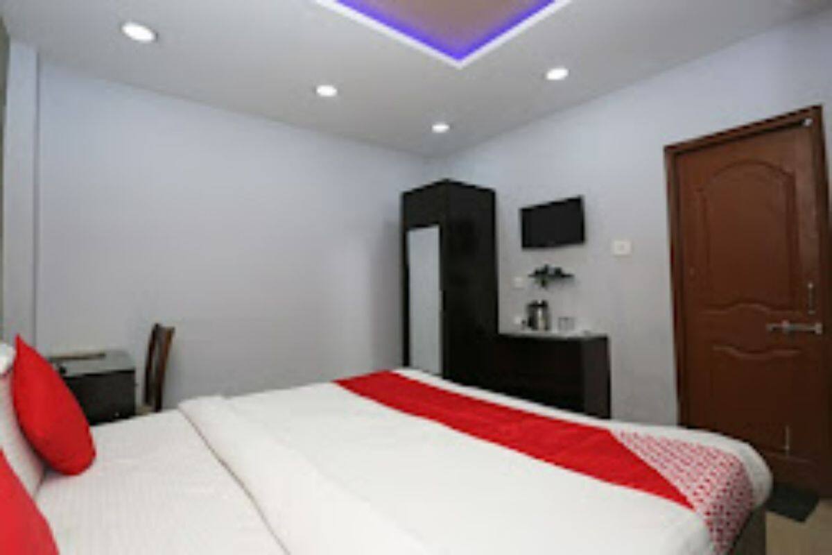 Una habitación de hotel con cama, escritorio, armario y puerta.