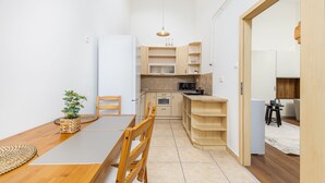 Una cocina compacta con comedor, muebles de madera y una pequeña planta.