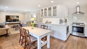 A modern kitchen with white cabinets, a central island, and stainless steel appliances. - 90 Walk Score, Steps to Beach, Dining (Carlsbad)