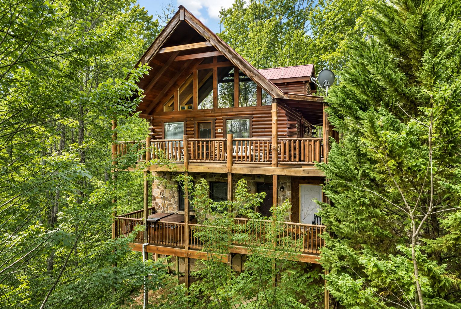 Une cabane dotée d’un balcon, entourée d’une forêt dense.