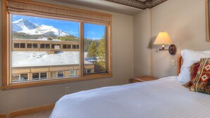A hotel room with a large window offering a view of a mountain and a building. - Summit View- Big Sky Shoshone Ski in/Out, Heated Pool (Big Sky)