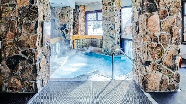 A stone-walled indoor pool with a clear view of the outdoors through a window. - Summit View- Big Sky Shoshone Ski in/Out, Heated Pool (Big Sky)
