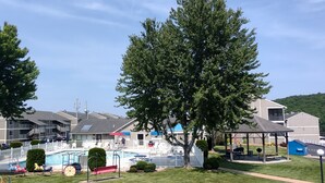 A residential area with a swimming pool, a gazebo, and a large tree. - 2 BEDROOM CONDO IN THE HEART of OSAGE BEACH at the LAKE!!! (Osage Beach)