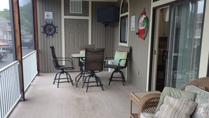 A covered outdoor area with a ceiling fan, a table with chairs, a wicker sofa, and a patterned rug. - 2 BEDROOM CONDO IN THE HEART of OSAGE BEACH at the LAKE!!! (Osage Beach)