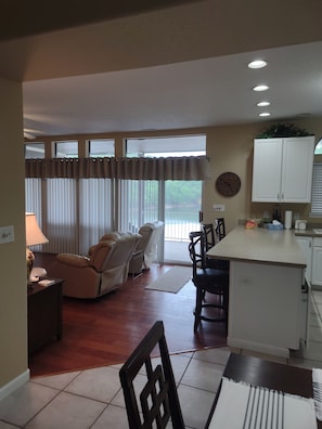 Relax in this spacious living area with a sofa, chairs, dining table, and kitchen.