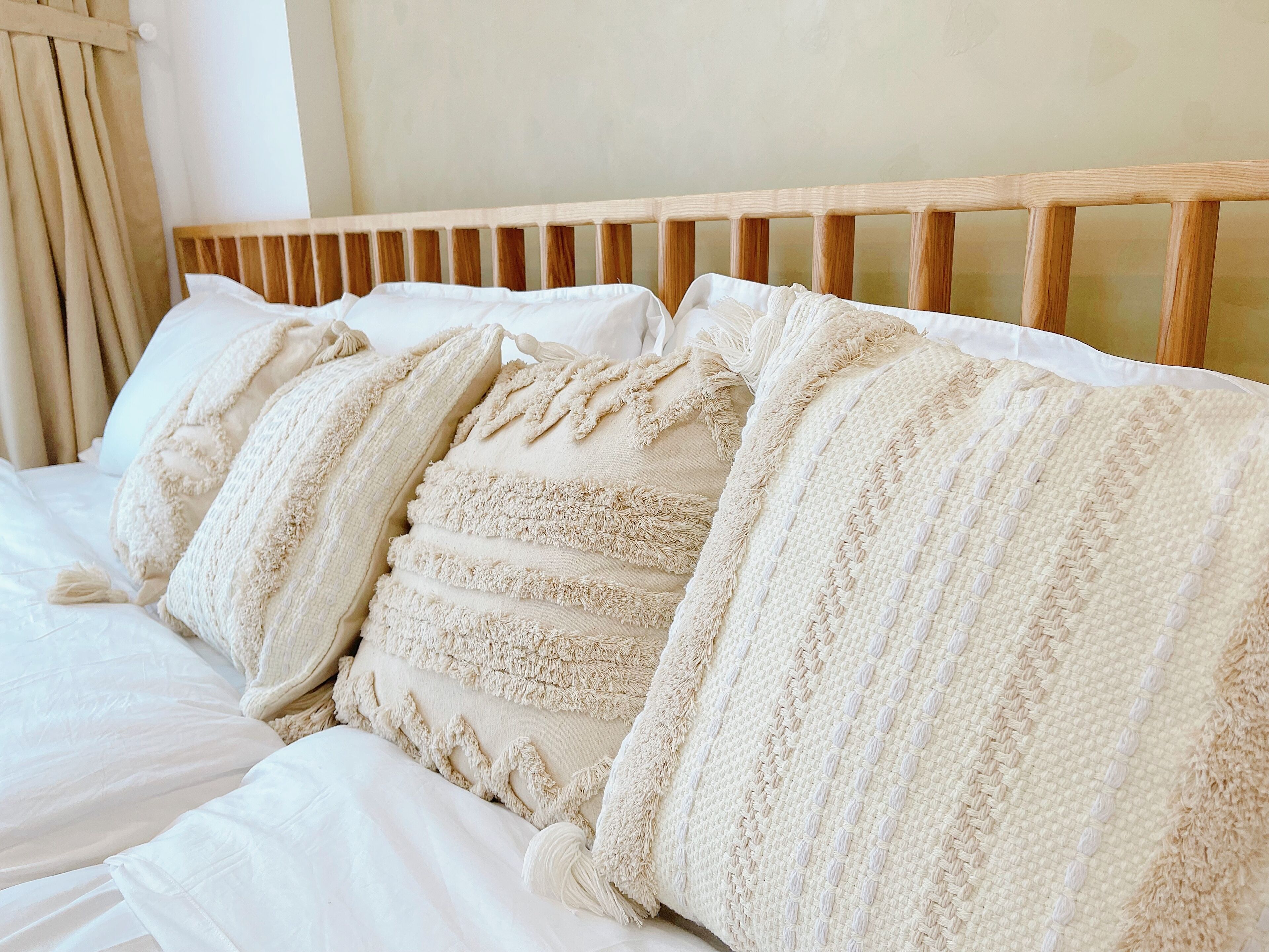 A bed with multiple pillows and a wooden headboard.