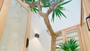 Een kamer met een houten kast, een wandlamp en verschillende groene planten.