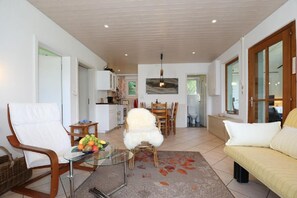 Relax in this inviting living area with a comfortable sofa, dining table, and armchair.