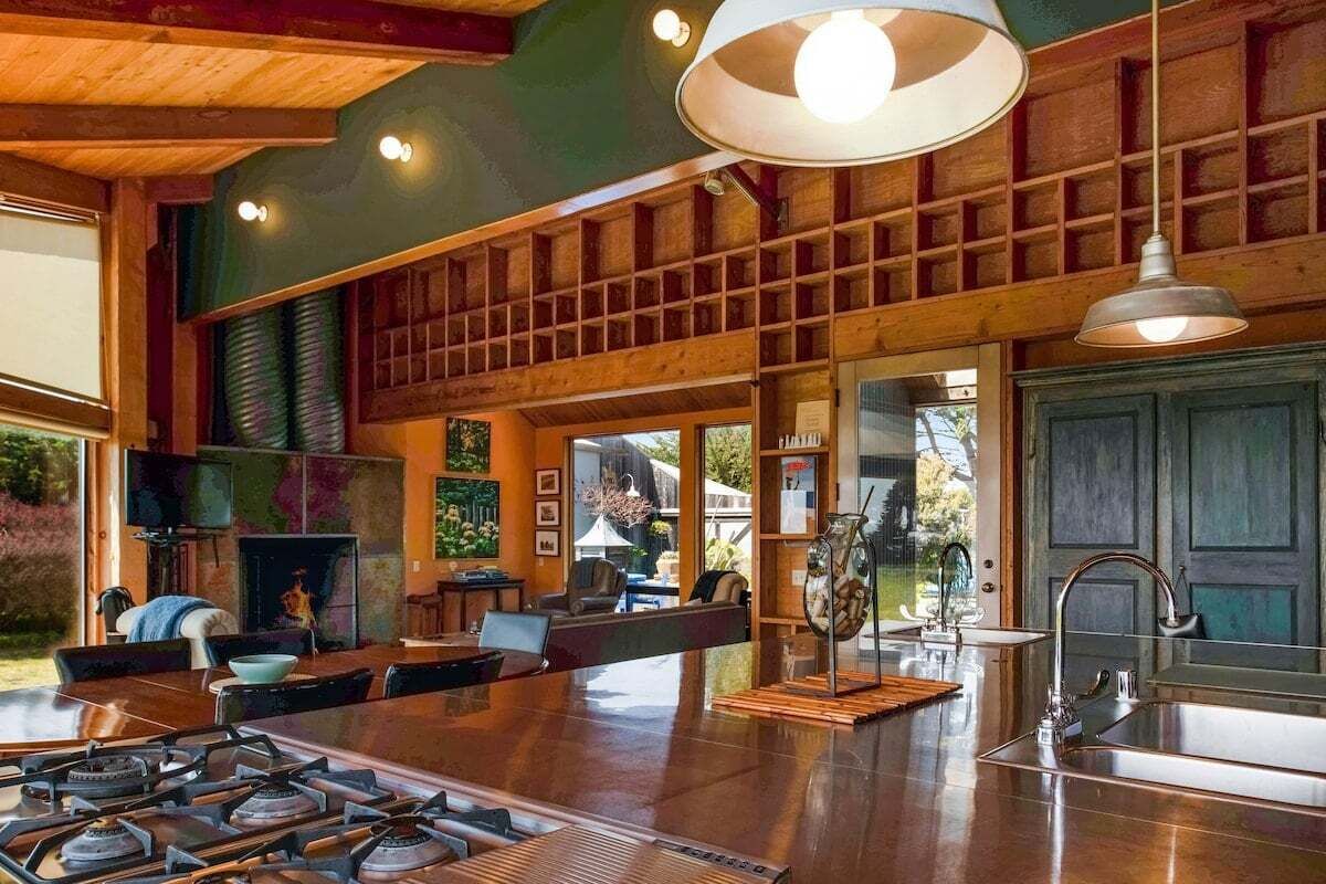 A spacious kitchen with a gas stove, a sink, and a dining area with a table and chairs.