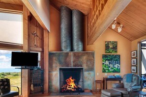 Una sala de estar acogedora con chimenea, televisor y un espacio de descanso confortable.
