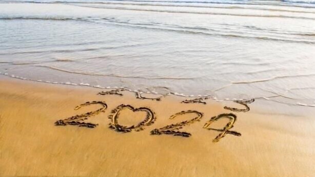Ein Strand mit dem Jahr '2024', das in den Sand geschrieben steht.