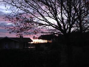 Ein Haus mit Dach und einem Baum im Vordergrund.