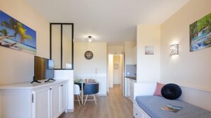 Un ambiente compatto con angolo cottura, zona pranzo e camera da letto.