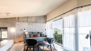 Une chambre moderne avec un grand lit, un bureau et une vue sur l’extérieur.