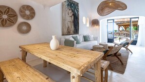 Ein modernes Wohnzimmer mit einem Holzespeisetisch, einem weißen Sofa und einem großen Gemälde an der Wand.
