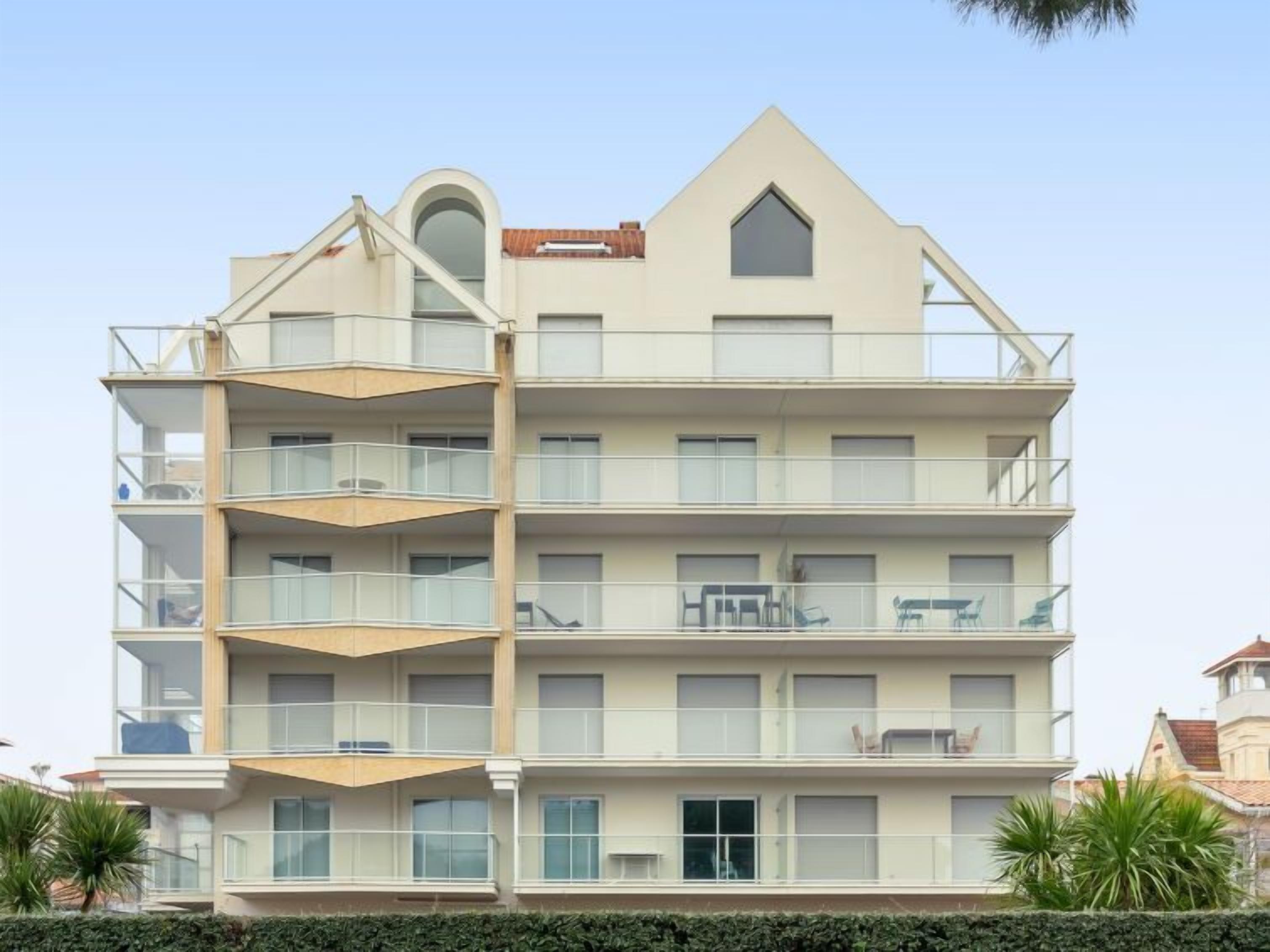 A multi-story building with balconies, large windows, and a distinct architectural design.