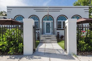 A modern building with a white facade, arched windows, and a gated entrance. - Stylish Hotel Room with Kitchenette (Miami)