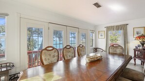 Un salón de conferencias con una gran mesa de madera, seis sillas tapizadas y amplias ventanas con vistas al exterior.
