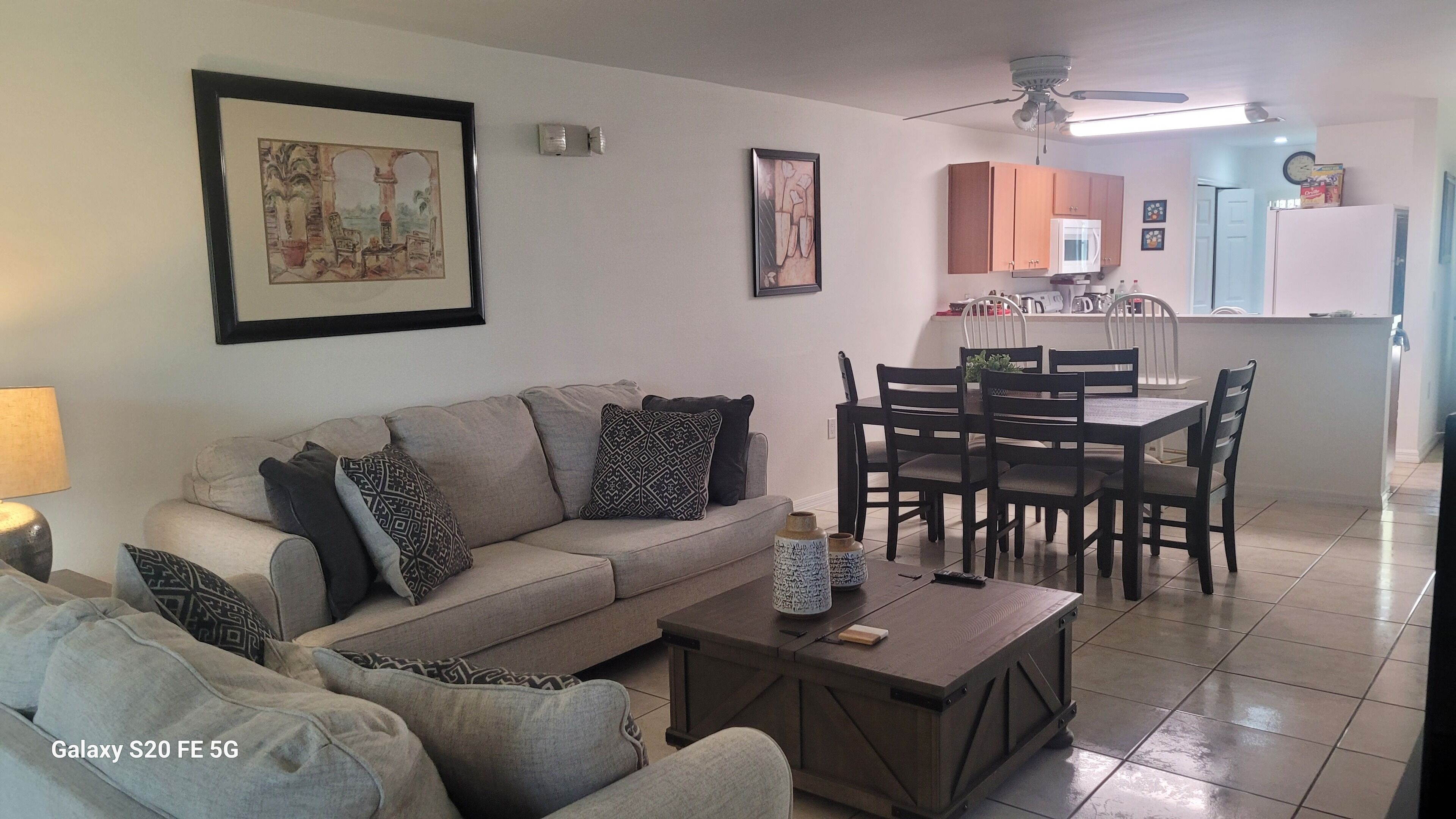 Ein Wohnzimmer mit Sofa, Couchtisch und Essbereich mit Stühlen und Tisch.