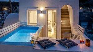 A modern outdoor pool area with a hot tub, seating, and a staircase leading to an upper level. - Santorita Suites (Santorini)