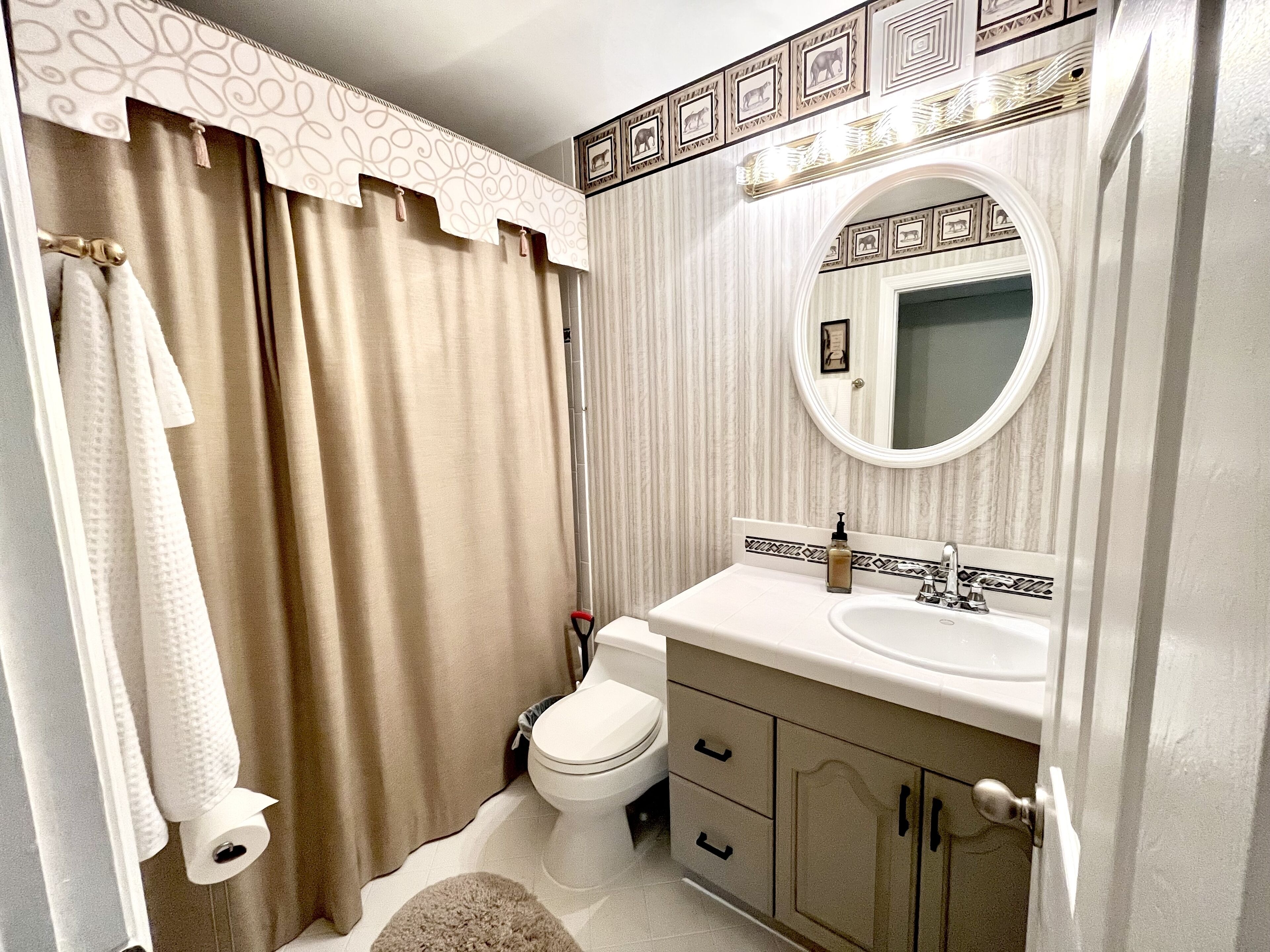 Une salle de bain avec des toilettes, un lavabo et un miroir.