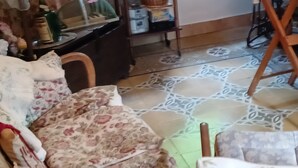 A room with a patterned floor, a wooden chair, and a table with various items. - ANCIENT HOUSE ON THE RIVER (Bagni di Lucca)