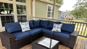 A sectional sofa with two decorative pillows on a wooden deck. - New Property at PK lake! (Graham)