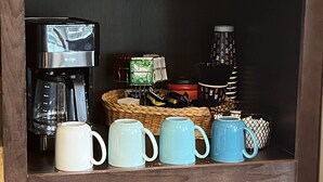 A coffee station with a coffee maker, mugs, and a basket of items. - New Property at PK lake! (Graham)