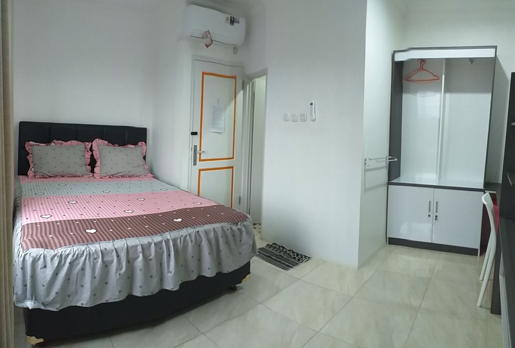 A bedroom with a bed, wardrobe, and a door with a lock.