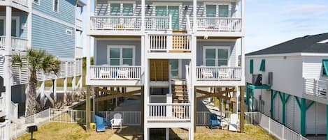 A multi-story building with a central staircase, balconies, and a covered deck area.