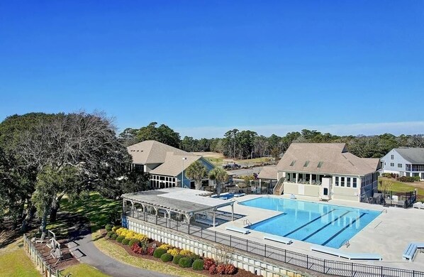 A swimming pool area with a covered deck, adjacent buildings, and a large tree. - Fairway To Heaven 3 Bedroom Home by RedAwning (Supply)