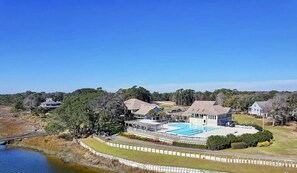 A large property with a swimming pool, multiple buildings, and a surrounding fence.