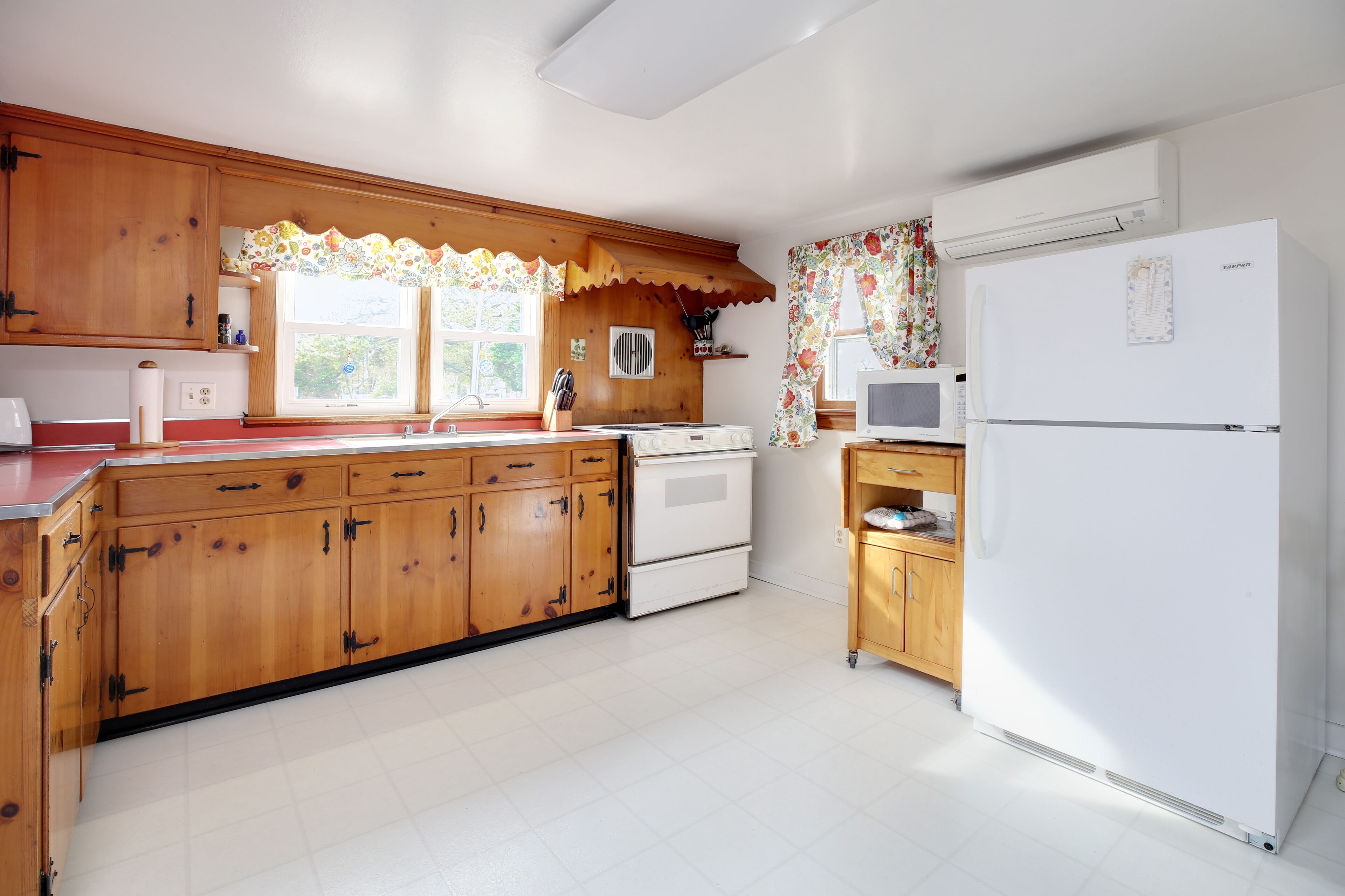 A kitchen with wooden cabinets, a white refrigerator, and a microwave.