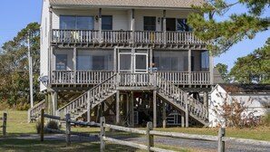 Un immeuble de deux étages doté d’un balcon à l’étage supérieur et d’un escalier menant à l’entrée.