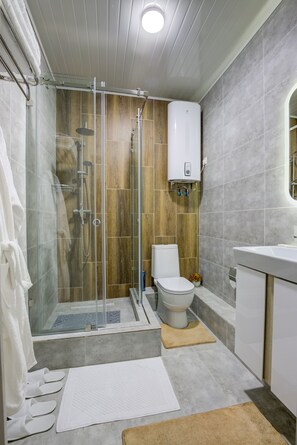 Une salle de bain moderne avec une douche à parois de verre, des toilettes et une baignoire.