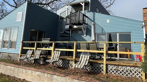A two-story house with a balcony and a deck. - 3-bedroom home,  waterfront patio,  fishing, kayaking, swimming, yoga room  (Trinity)