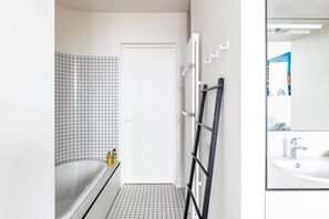 Bathtub, rainfall showerhead, hair dryer, towels